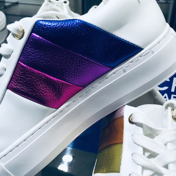 close up of white trainers with coloured stripes